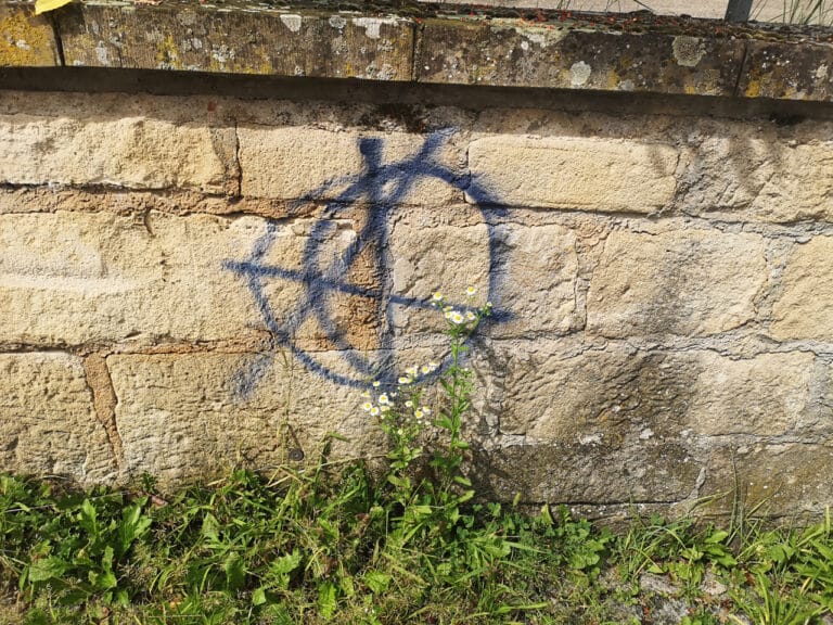 Graffiti-Entfernung auf einer Sandstein Wand eines Marktplatzes