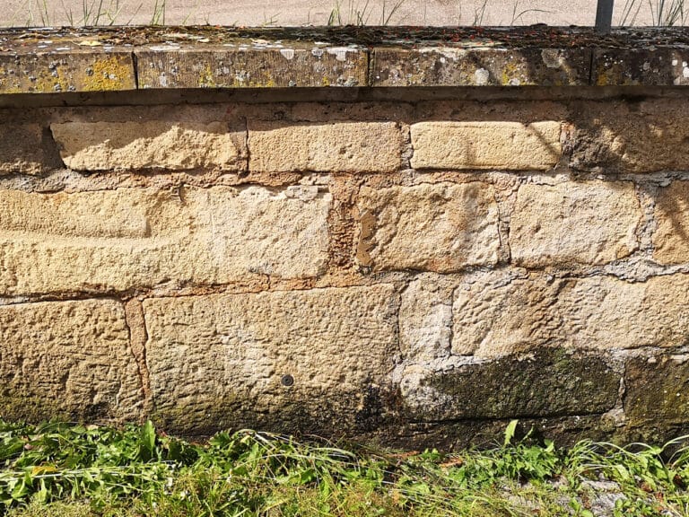 Graffiti-Entfernung auf einer Sandstein Wand eines Marktplatzes